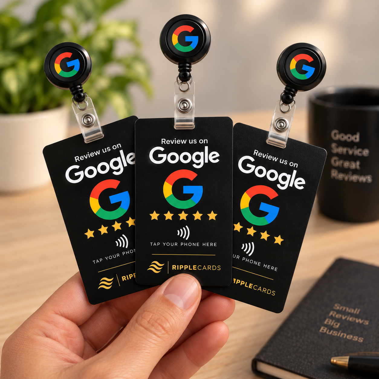 Three RippleCards review badges held over a warm desk