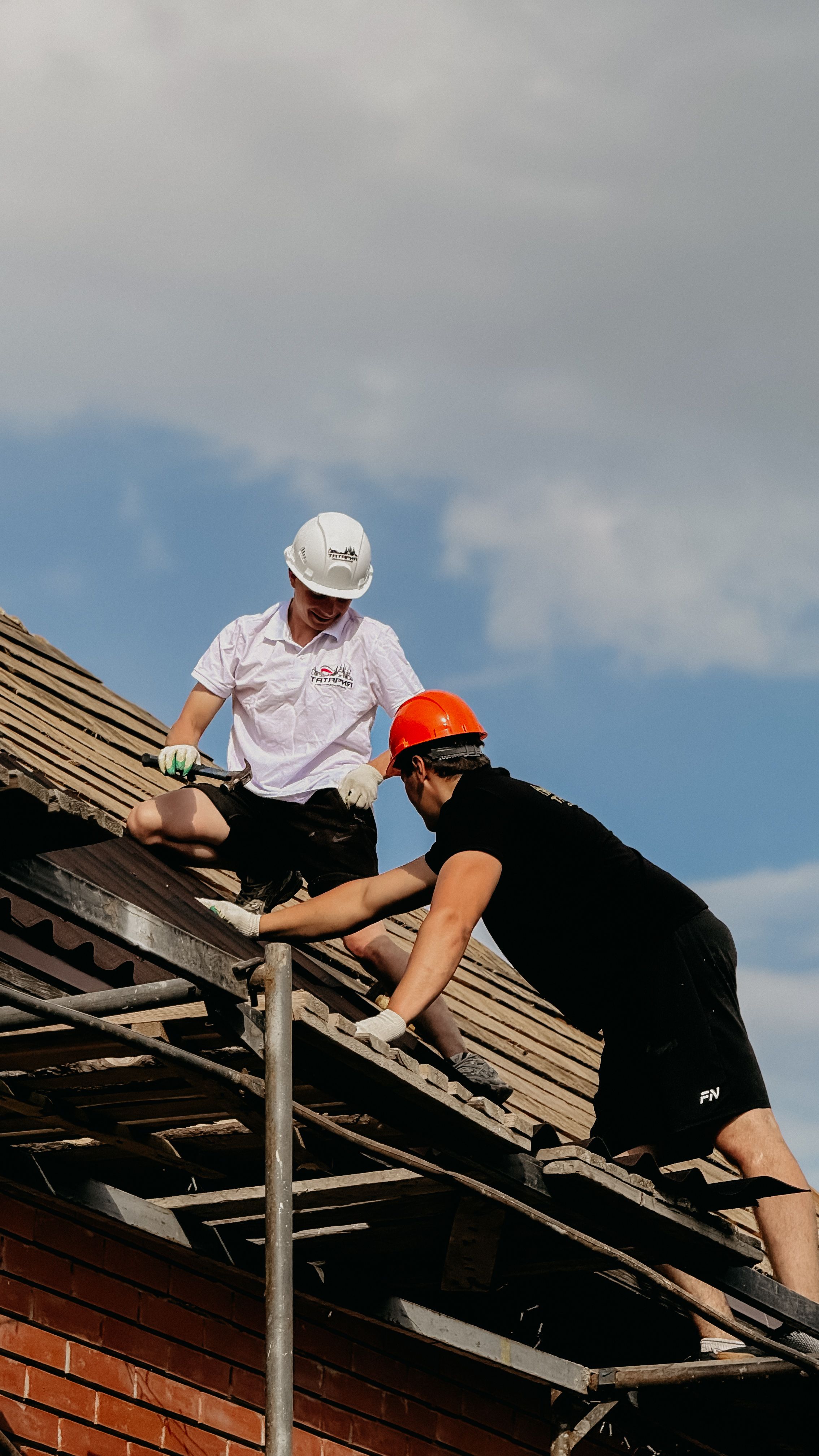Roofers installing shingles on a residential roof